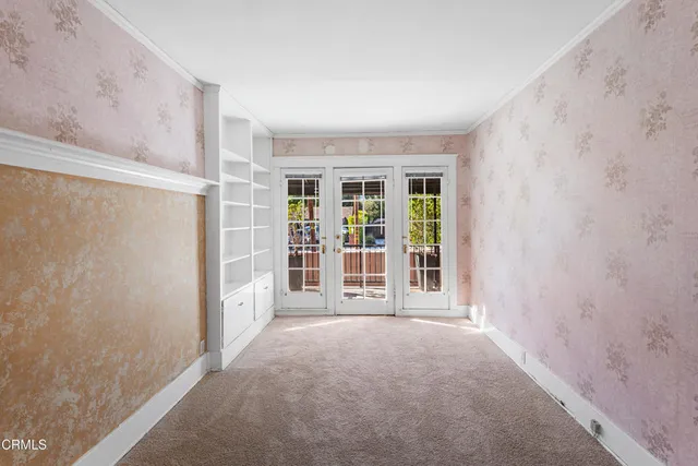 an empty room with windows and ceiling fan