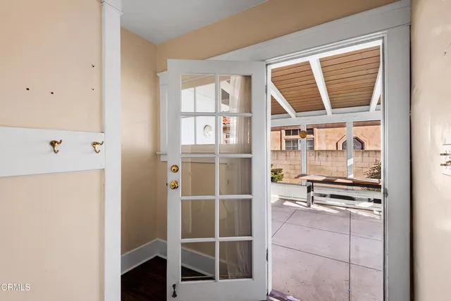 a view of a porch with chairs and couches with wooden roof and floor to ceiling window