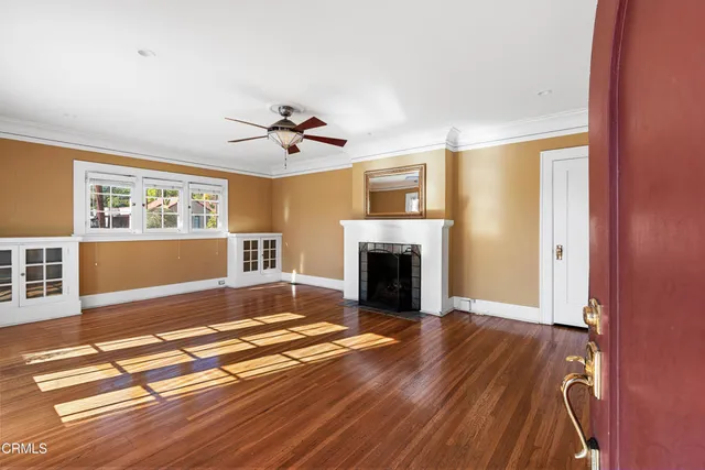 a view of empty room with wooden floor and fireplace