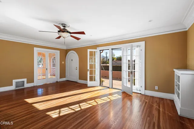 a living room with wooden floor and large window