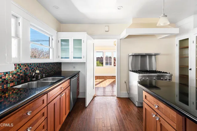 a kitchen with stainless steel appliances kitchen island granite countertop a stove and a sink