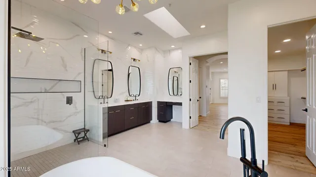 a bathroom with double vanity sink a mirror a bathtub and shower