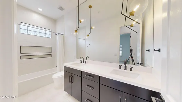 a bathroom with a double vanity sink a mirror and a bathtub