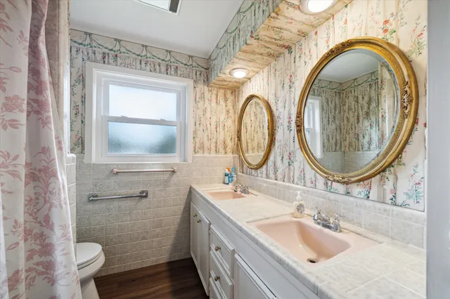 a bathroom with a granite countertop toilet a sink and a mirror
