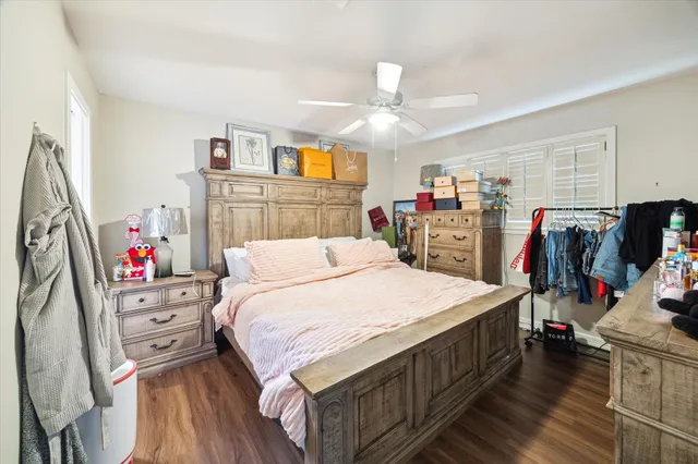 a bed room with a bed a flat tv screen and a dresser