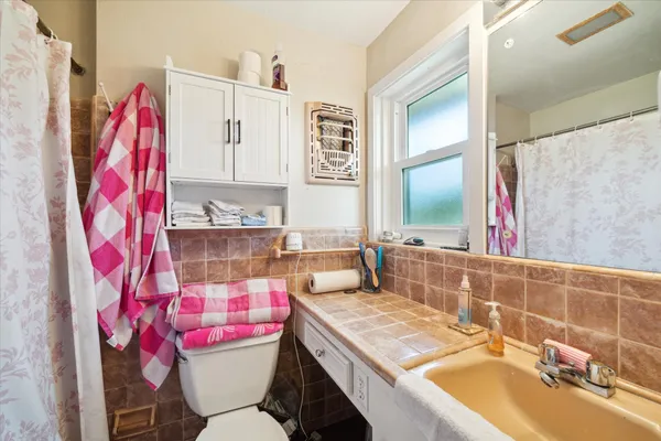 a bathroom with a sink vanity mirror and toilet