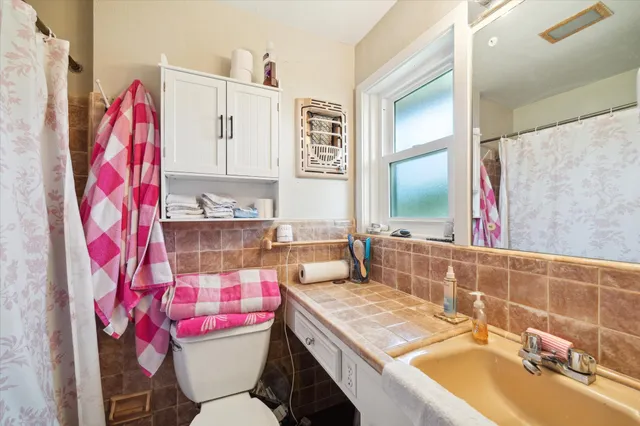 a bathroom with a sink vanity mirror and toilet