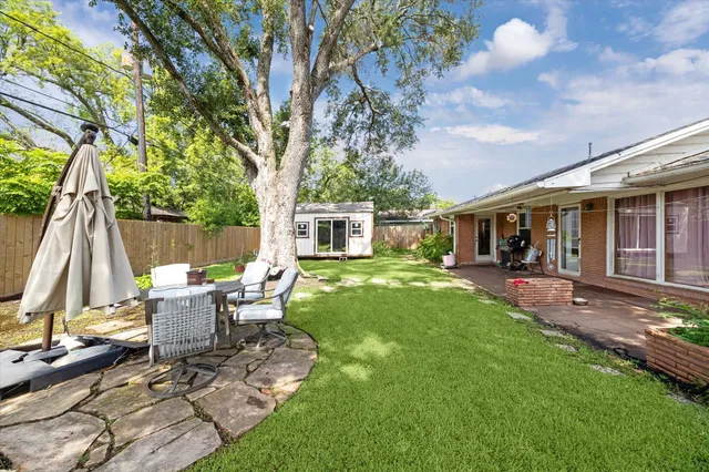 a view of a house with backyard sitting area and garden