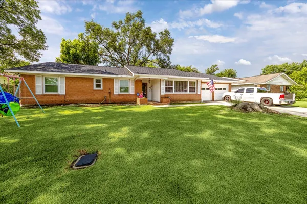 a front view of a house with a yard and trees