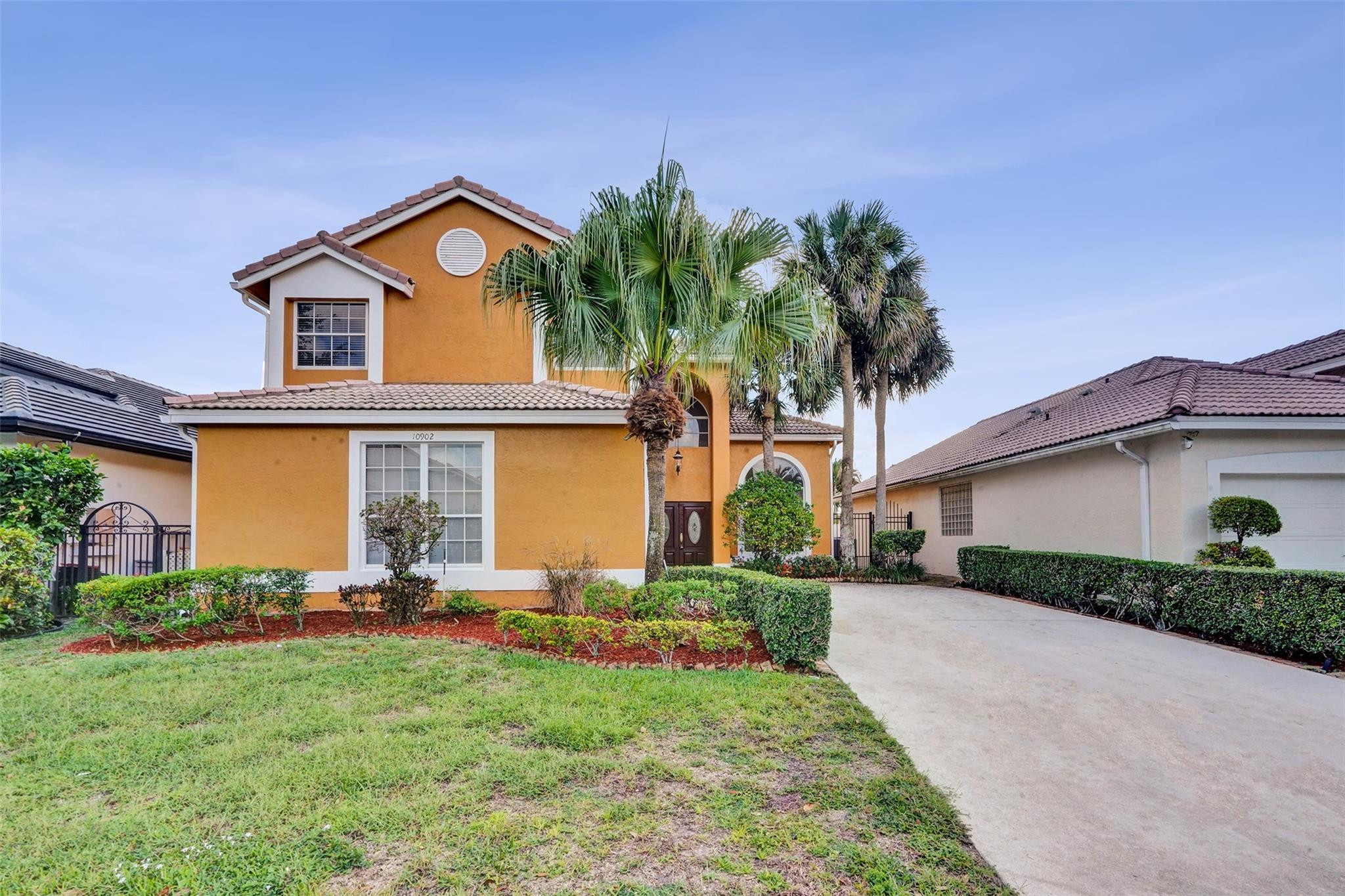 10902 Tamoron Lane Boca Raton, FL 33498 - Photo 65 of 66 a front view of a house with a yard and garage