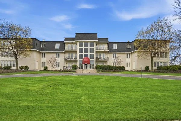 a view of a big house with a big yard and large trees