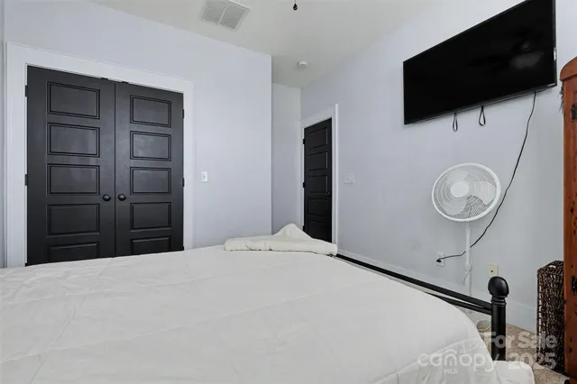 a bedroom with a bed and a flat screen tv