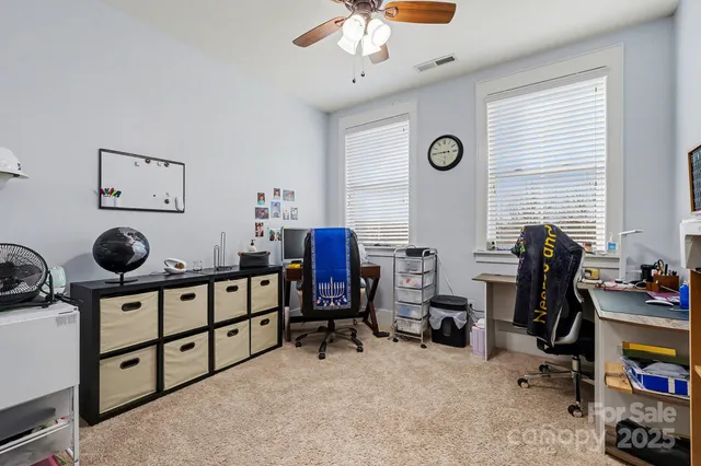 a view of a workspace with furniture and a window