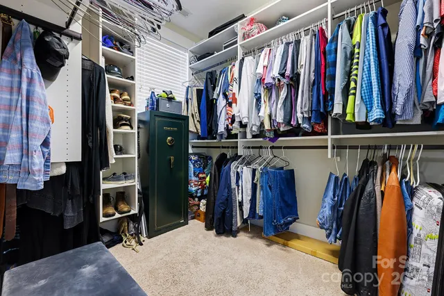 a view of walk in closet with clothes and shoes