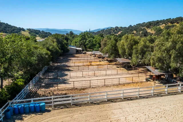 an aerial view of a house with yard and mountain view in back