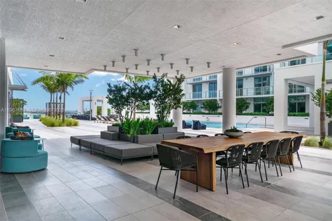 a living room with patio furniture and a floor to ceiling window