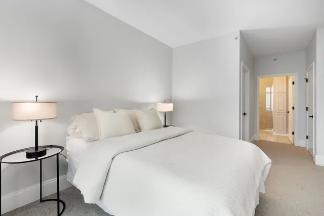 a spacious bedroom with a bed and a lamp