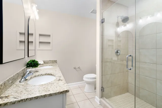 a bathroom with a granite countertop sink toilet and shower