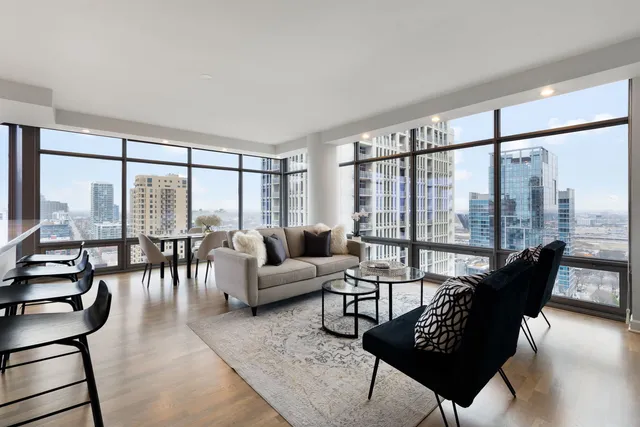 a living room with furniture and a large window with balcony view