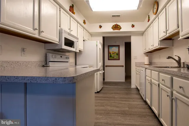 a kitchen with stainless steel appliances granite countertop a sink and dishwasher a stove with wooden floor