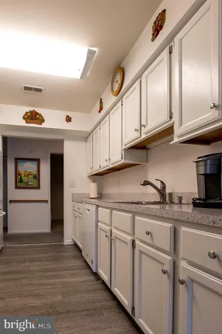 a kitchen with granite countertop a sink and cabinets