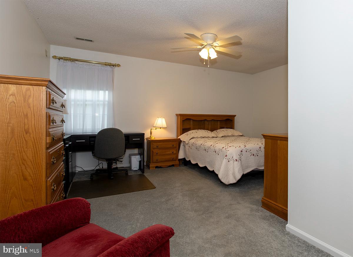 2000 Miller Avenue, Unit 26 Millville, NJ 08332 - Photo 20 of 25 a bedroom with bed and a chandelier