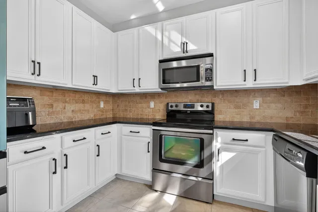 a kitchen with stainless steel appliances a stove sink and microwave