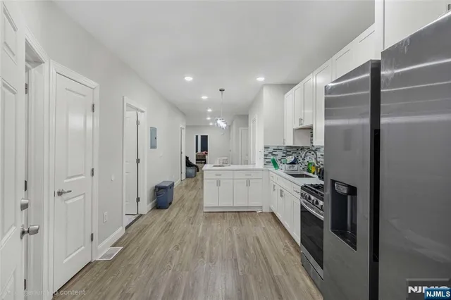 a kitchen with a refrigerator and white cabinets