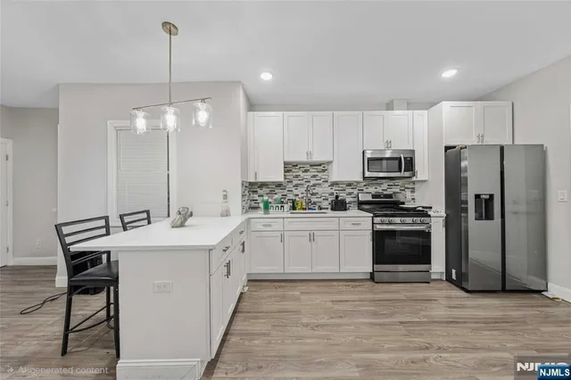 a kitchen with kitchen island a sink appliances and cabinets