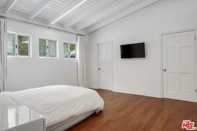 a bedroom with a bed and a flat screen tv