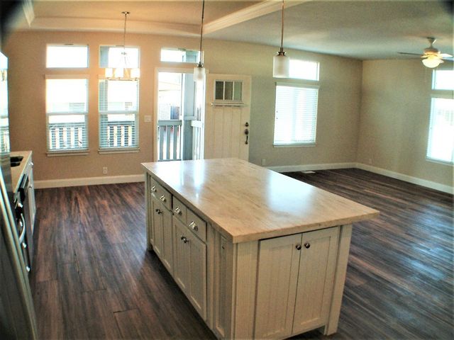a kitchen with a wooden floor window and wooden floor