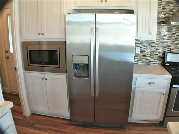 a close view of a refrigerator in kitchen and white cabinets