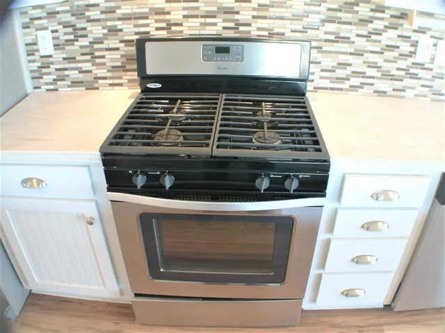 a stove top oven sitting inside of a kitchen