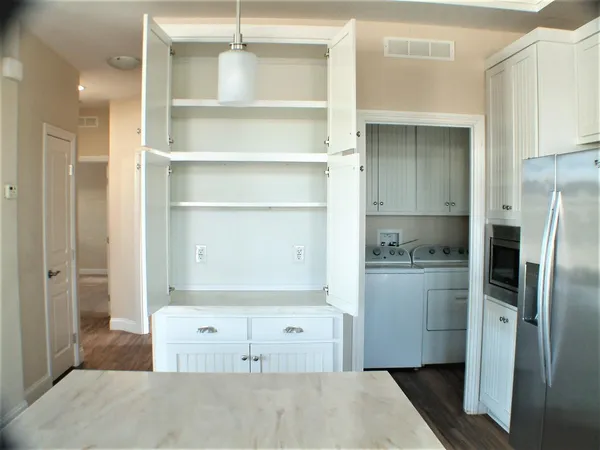 a kitchen with a refrigerator and white cabinets