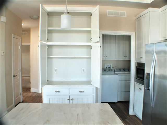a kitchen with a refrigerator and white cabinets