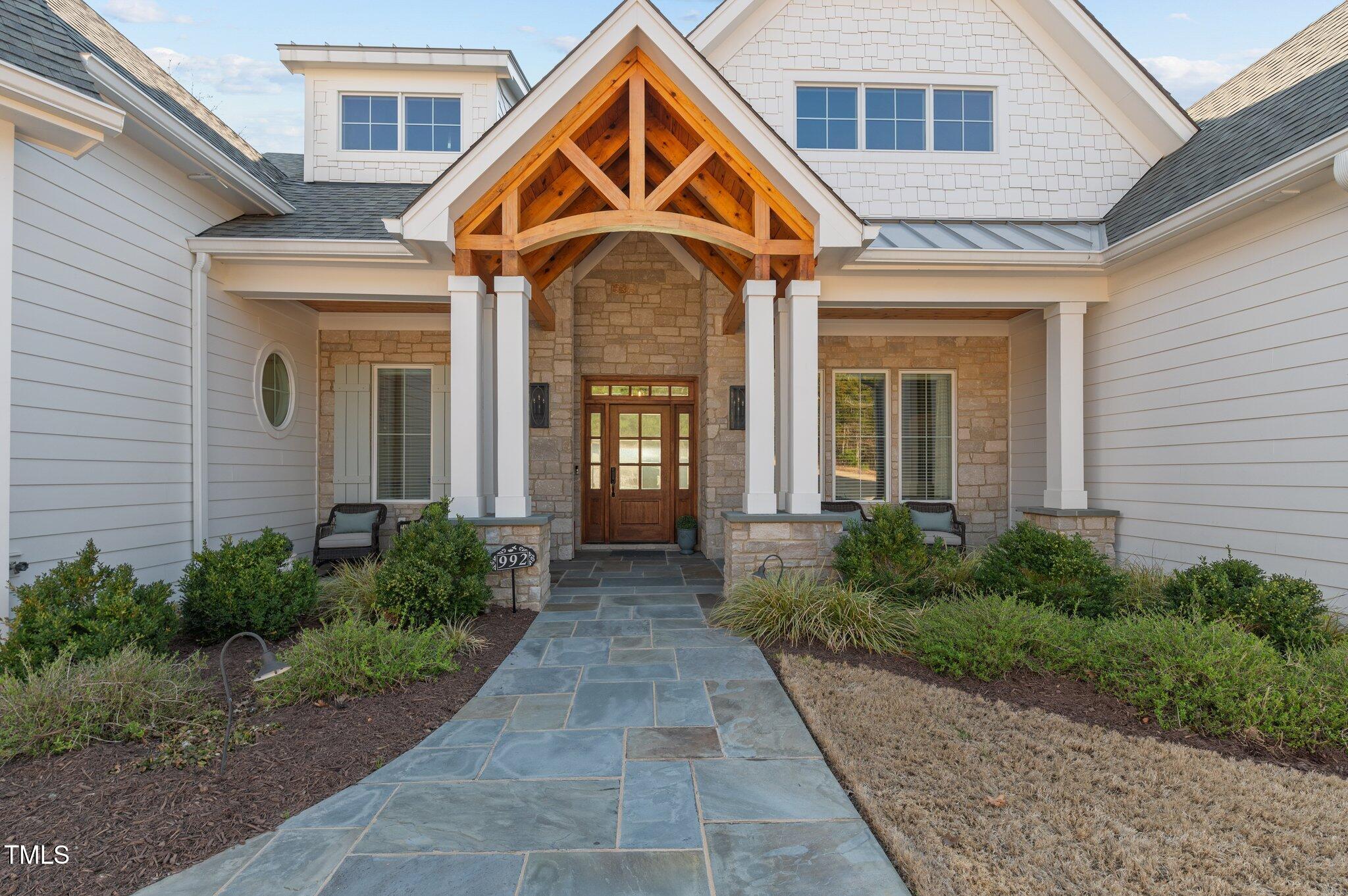 992 Estate Road Semora, NC 27343 - Photo 10 of 77 a view of a brick house with large windows and a yard