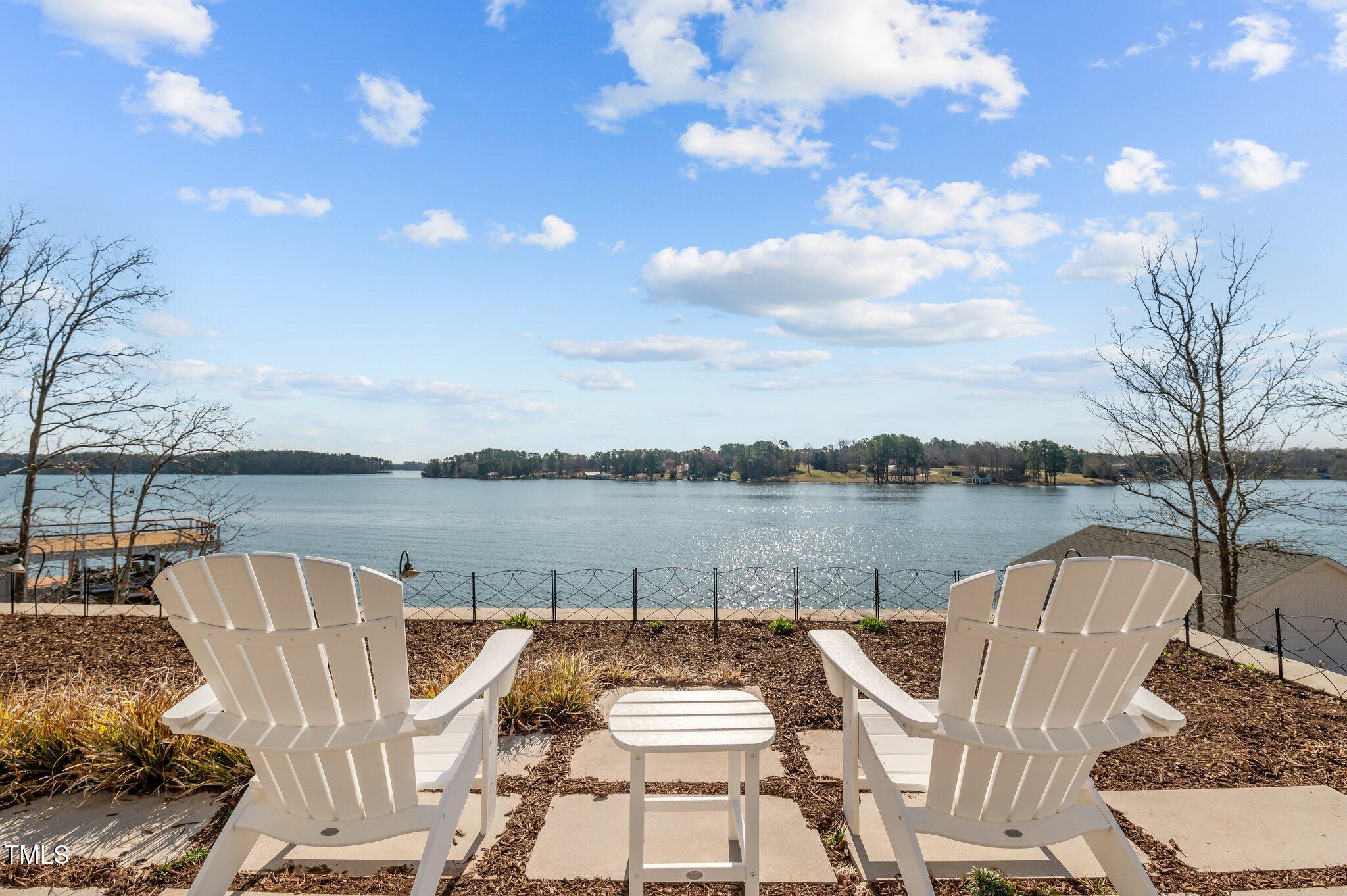 992 Estate Road Semora, NC 27343 - Photo 54 of 77 a view of a lake with couches chairs and wooden floor