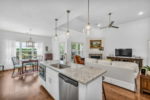 a kitchen with stainless steel appliances granite countertop a stove and a wooden floor