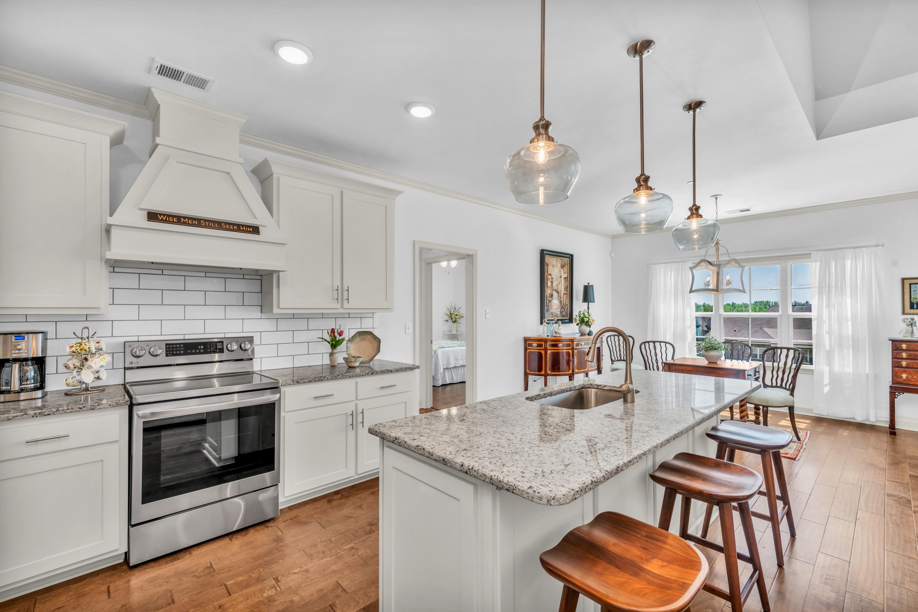 20 Thorpe Cove Piperton, TN 38017 - Photo 16 of 39 a kitchen with stainless steel appliances granite countertop a stove a kitchen island a dining table and chairs with wooden floor