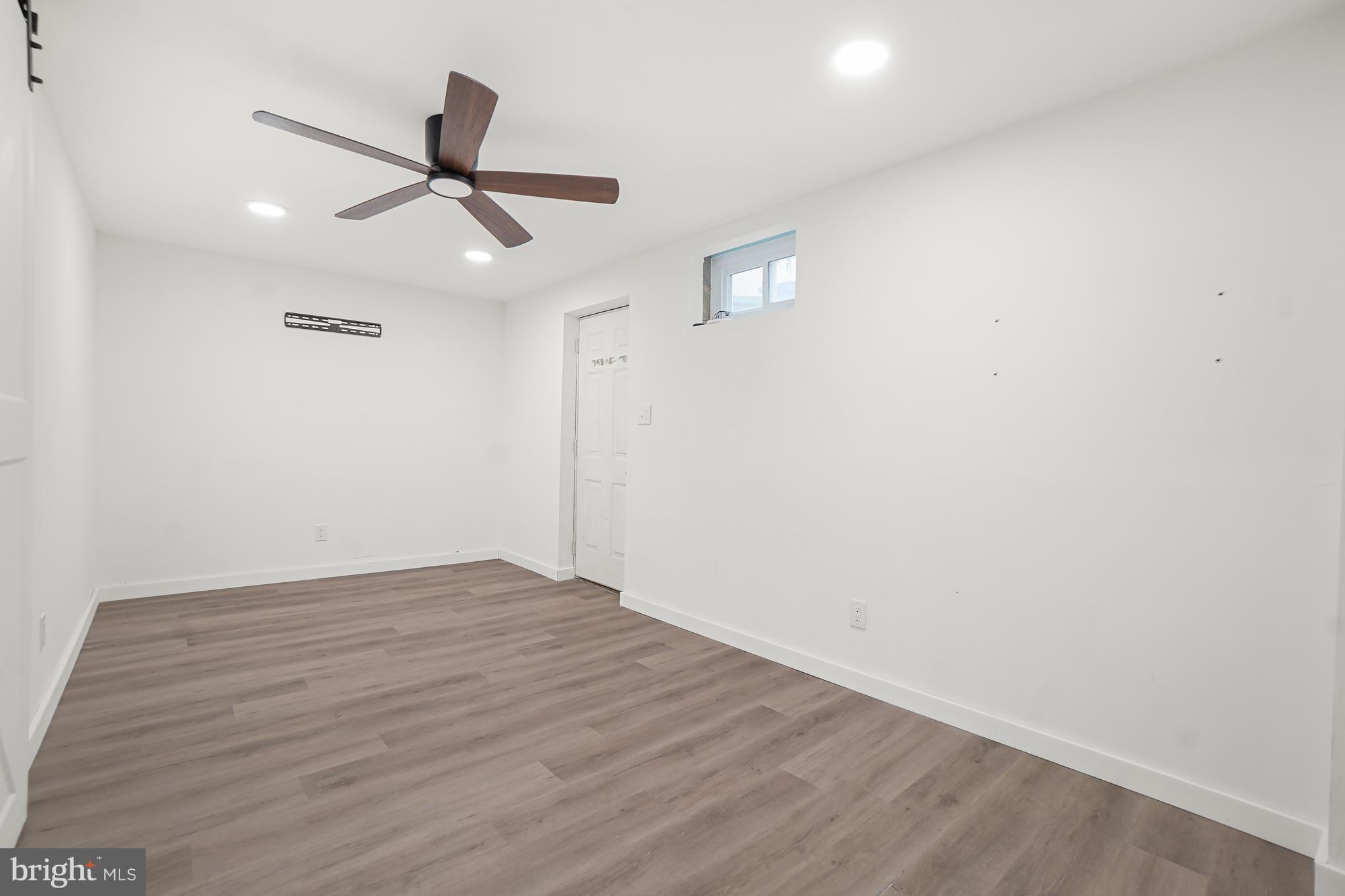 7994 Windsail Court Frederick, MD 21701 - Photo 37 of 46 an empty room with wooden floor ceiling fan and windows