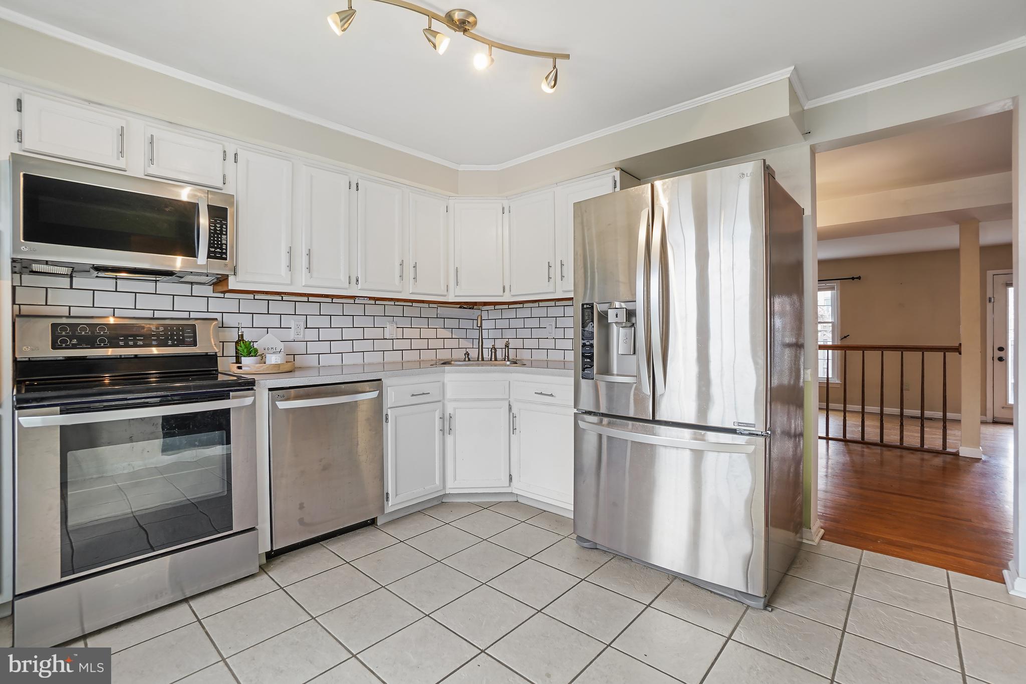 7994 Windsail Court Frederick, MD 21701 - Photo 5 of 46 a kitchen with granite countertop a refrigerator and a stove top oven