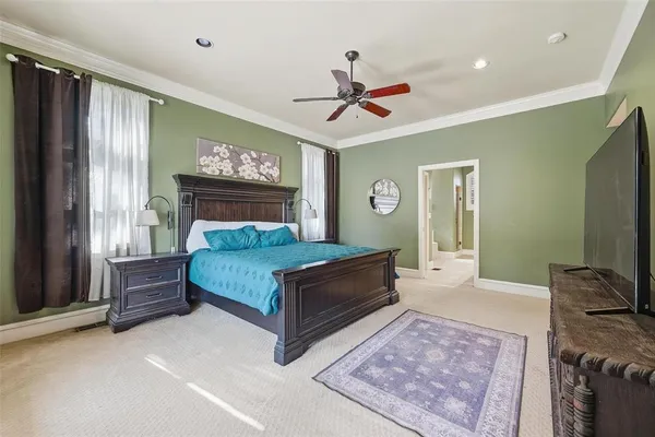 a bedroom with a large bed and a chandelier