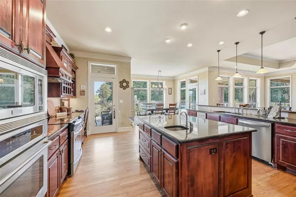 a kitchen with stainless steel appliances granite countertop a stove refrigerator and a wooden cabinets