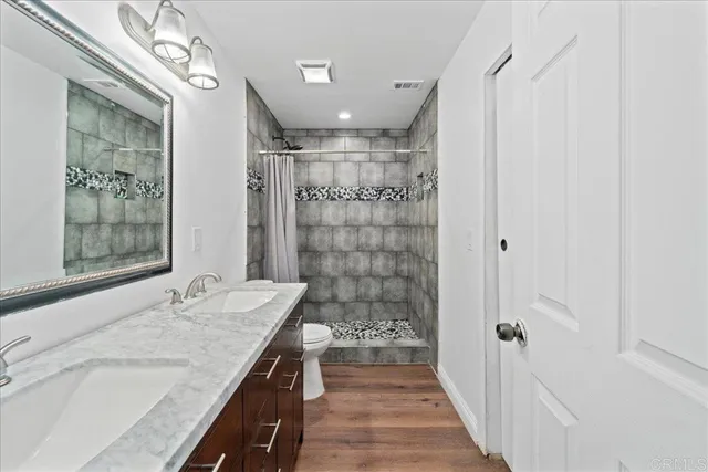 a bathroom with a granite countertop sink a large mirror and shower
