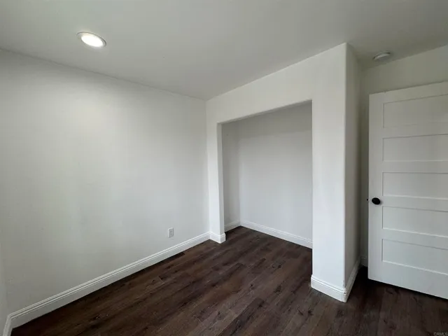 an empty room with wooden floor and closet