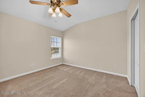an empty room with a chandelier fan