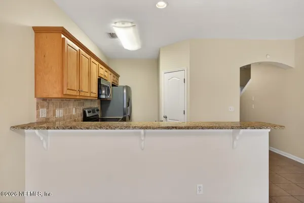 a kitchen with stainless steel appliances granite countertop a stove a microwave and a refrigerator