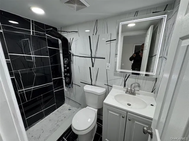a bathroom with a toilet a sink and a mirror