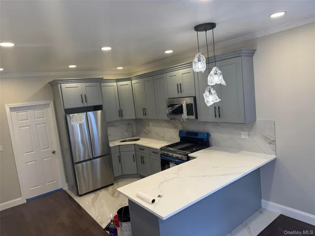 a kitchen with stainless steel appliances a stove a refrigerator and more cabinets