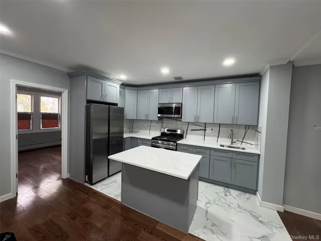 a kitchen with a sink a counter top space stainless steel appliances and cabinets